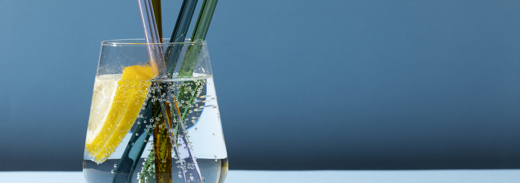 Transparent Glass With Fizzy Water And Colored Glass Straws