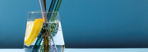 Transparent Glass With Fizzy Water And Colored Glass Straws